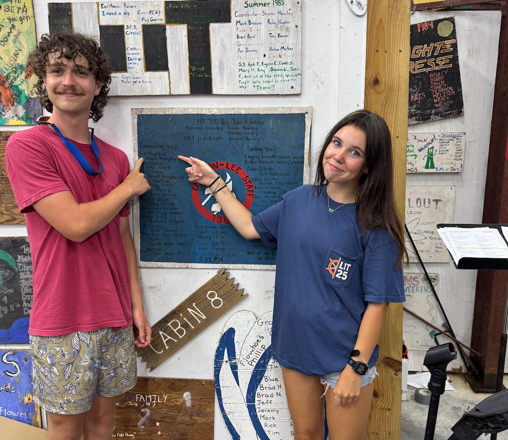 Screenshot 2025-09-18 at 10.30.50 AM Summer Staff Ben Stafford and Ollie, first cousins, point to 1985 Staff Board, which includes Sid Stafford, Ben's father
